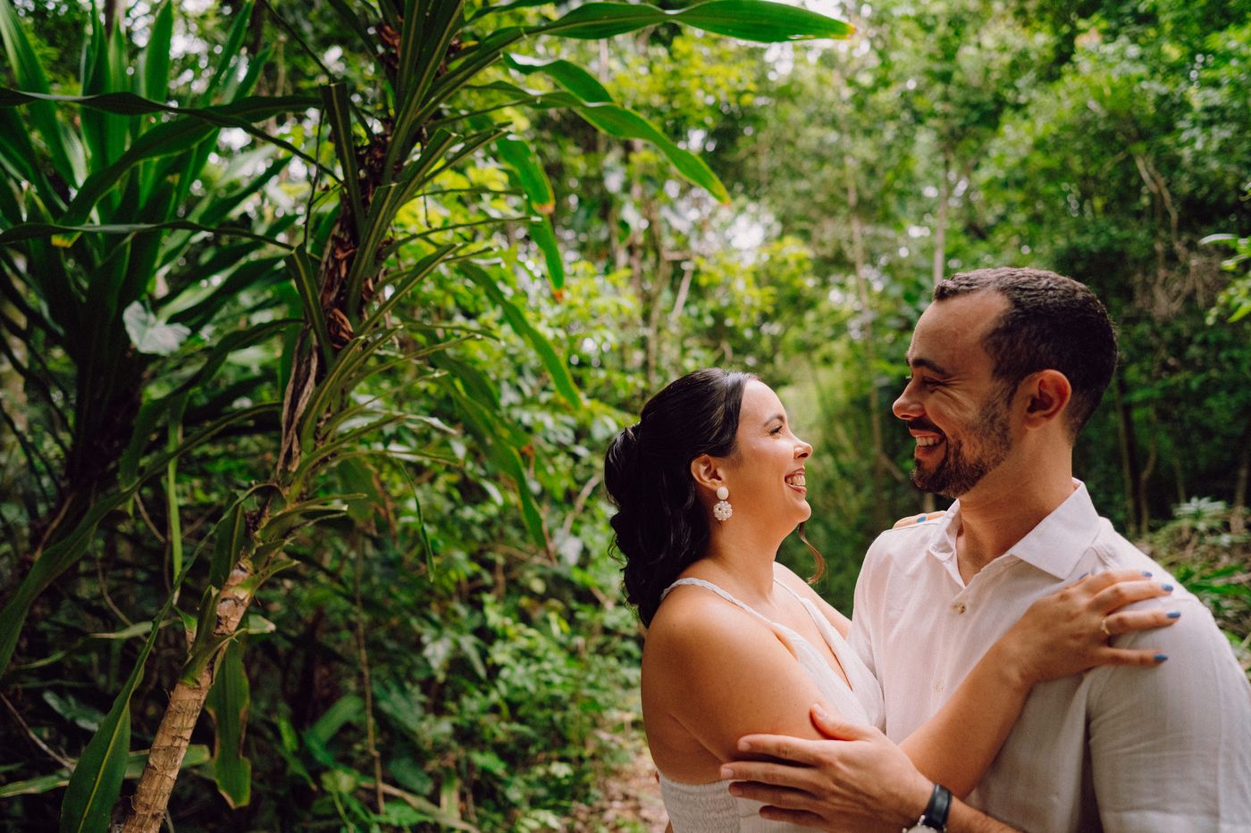 Lara e Luiz abraçados em meio à vegetação
